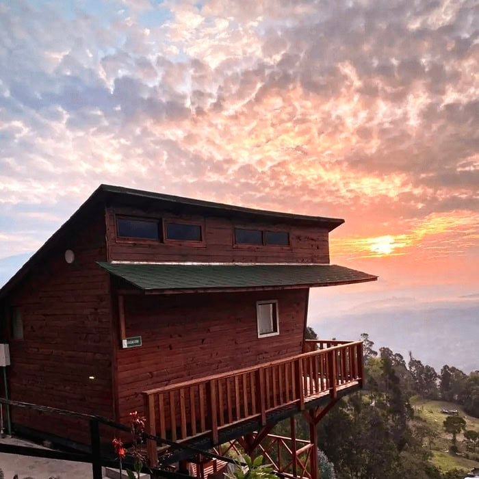 Cabaña de Glamping La Kumbre con un atardecer de fondo y montañas al horizonte